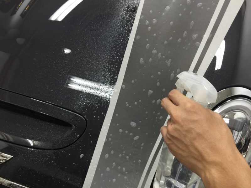 MINI R55,56,57 エンジンフードストライプインストール時デカール側にも水溶液をかけている様子