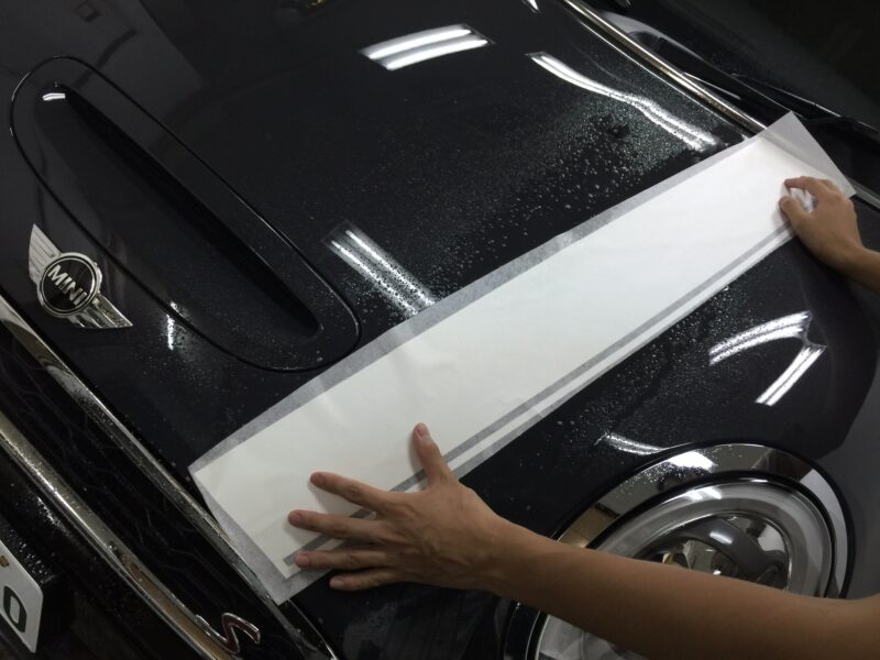 MINI R55,56,57 エンジンフードストライプインストール時位置合わせをする様子