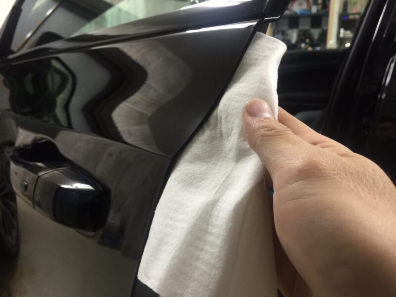 ドアエッジプロテクションフィルムを貼るためにドアをウエスで拭いている