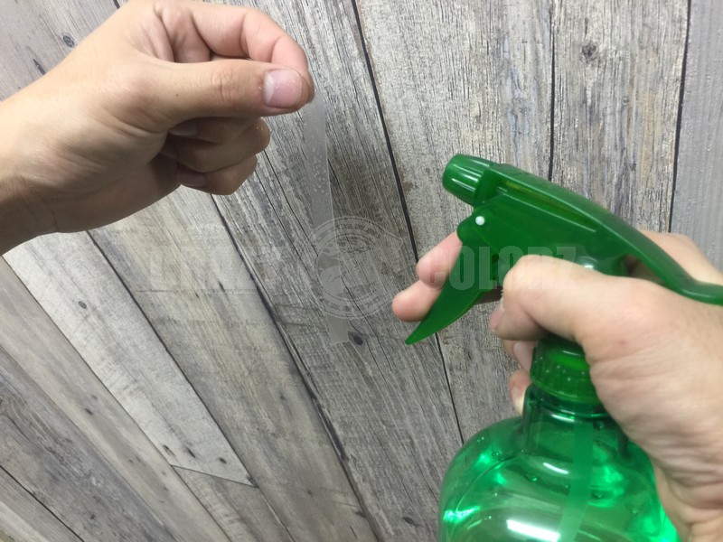 ドアエッジプロテクションを施工前に水溶液をかけている様子