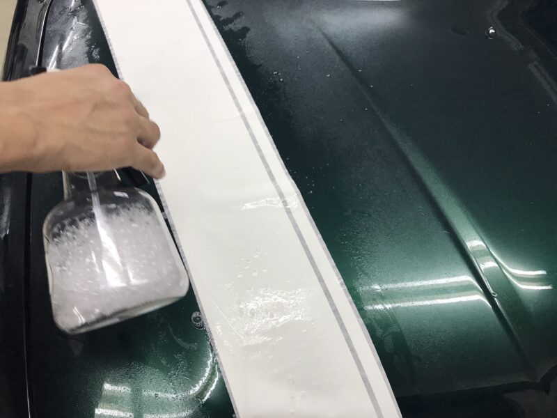 ミラジーノレーシングストライプのインストールマニュアルでの水溶液をかけている様子
アプリケーションの上から水をかけている