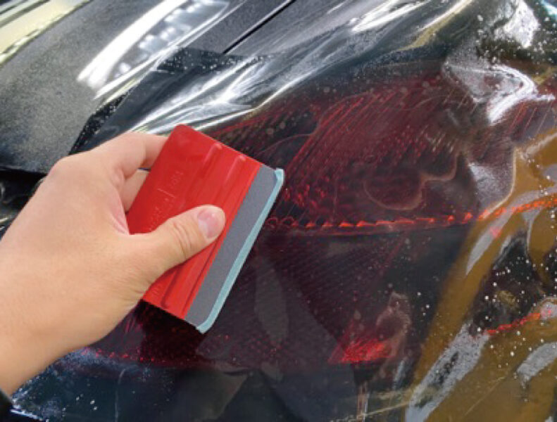 スモークフィルムを今まさにテールランプにラッピングする様子