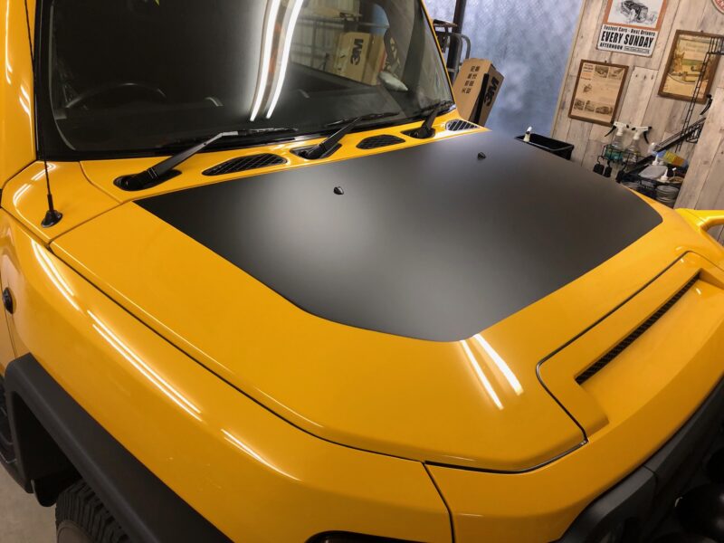 fjクルーザーのボンネットフィルムの施工後完全に乾いた時にエア残りがないか確認するところ