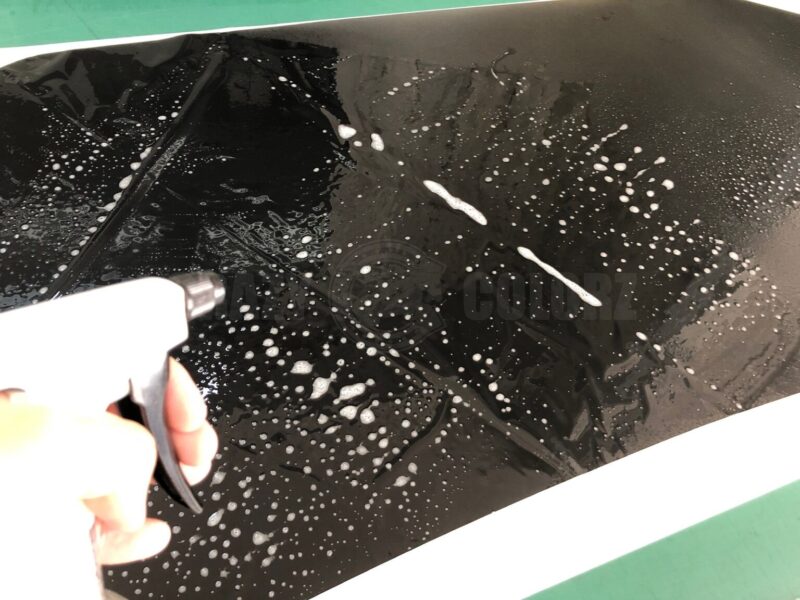 施工するフィルムを台紙から剥がし、デカール裏面（糊面）にも水溶液を吹く下準備