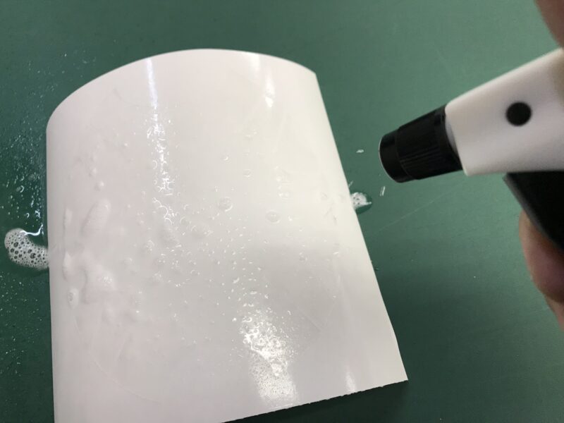 ドアノブプロテクションを施工前に水をかける様子