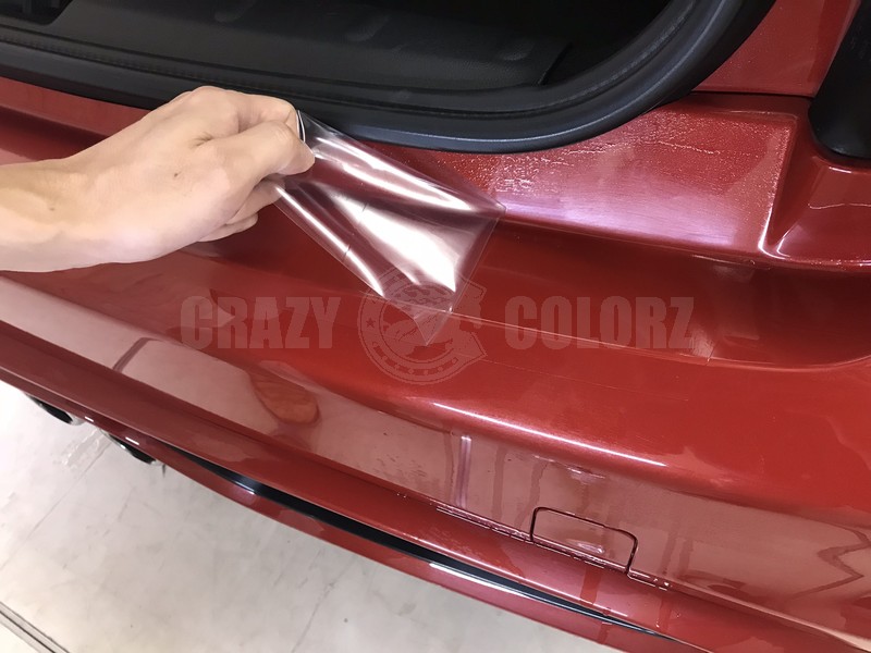 MINI Cooper Sのリアバンパープロテクション施工後に表面の保護フィルムを剥がしている様子
